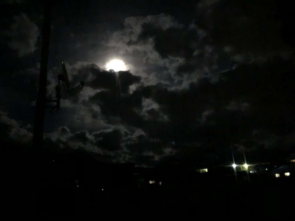 雲の間から見える月と夜の街の灯り