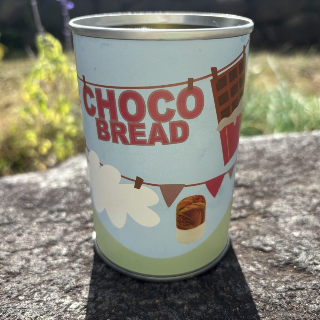 青空の下に置かれたチョコブレッドの缶詰