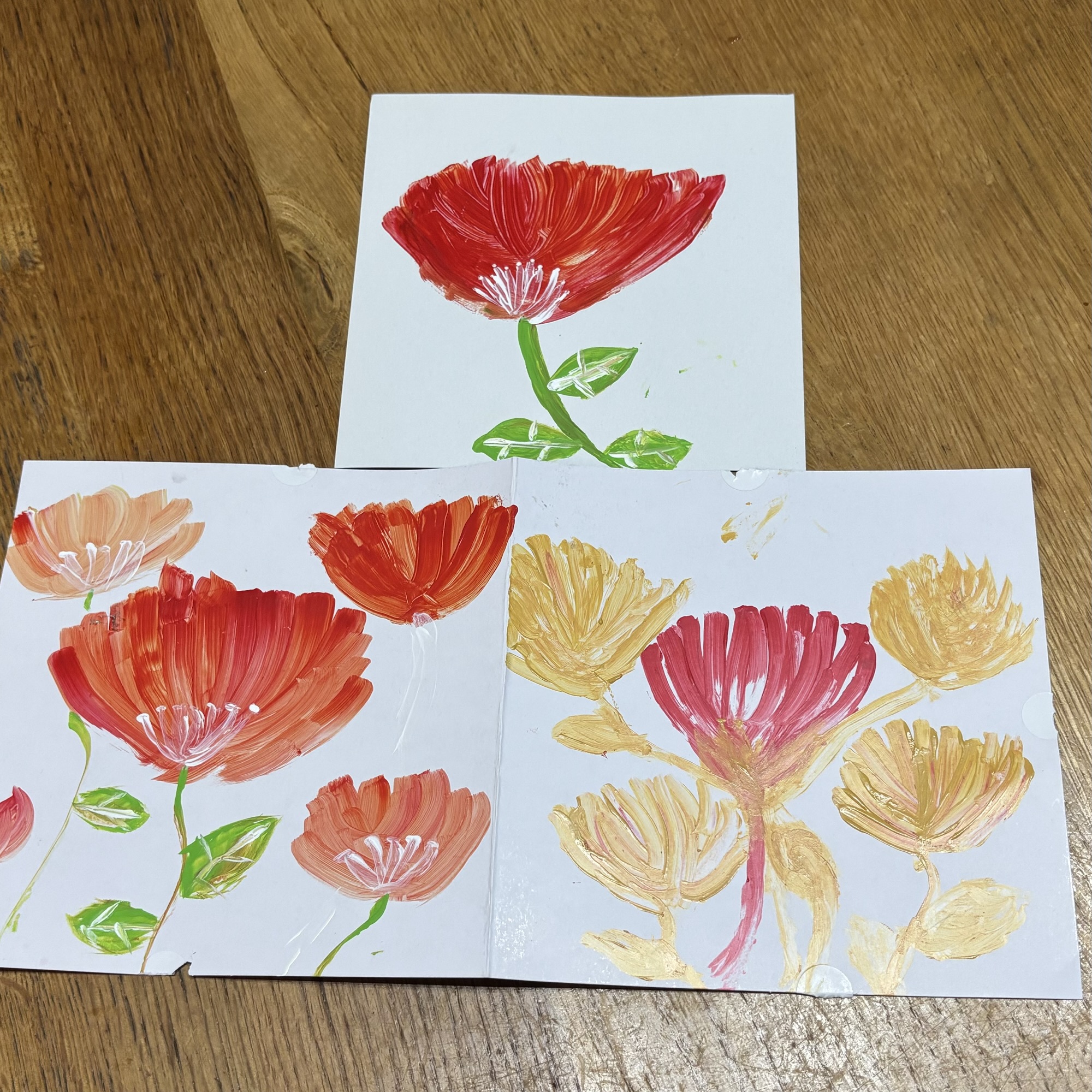 赤とオレンジを重ねて描かれた子どもの花の絵