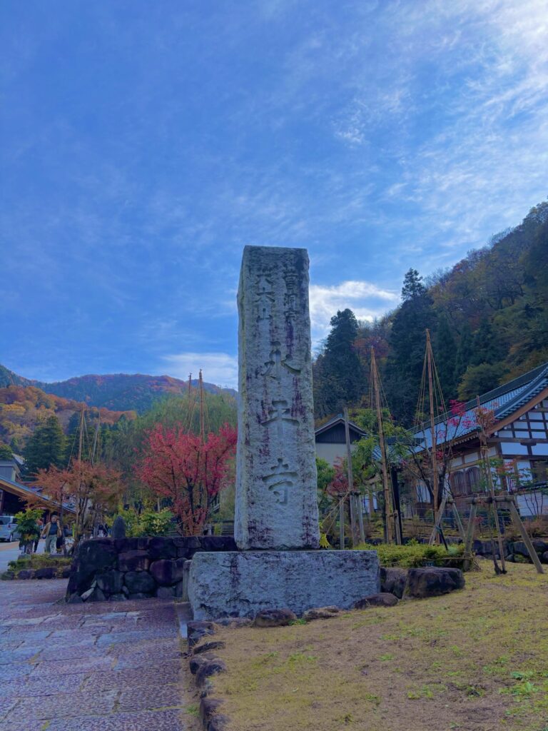 永平寺の入り口に立つ石柱と紅葉の山