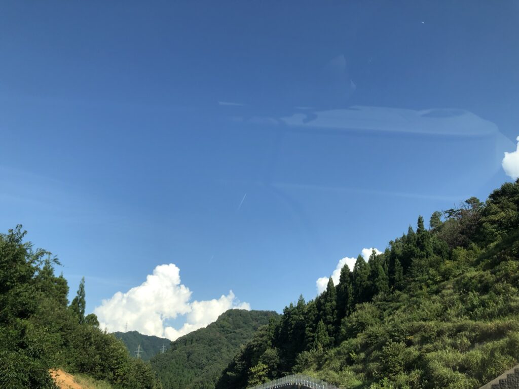 広い青空と山々、夏のような白い雲が広がる景色