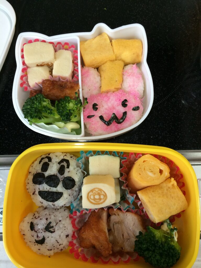 ピンクのうさぎの顔をかたどったごはんが入った手作り弁当